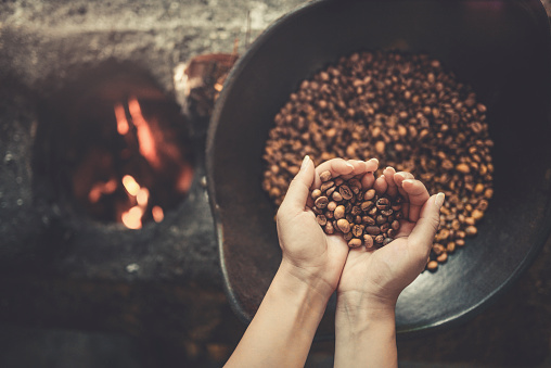 Antigua forma tradicional de tostar granos de café crudos en llamas photo