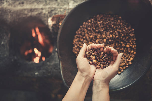vecchio modo tradizionale di arrostire i chicchi di caffè crudo in fiamme - coffee bag coffee bean bean foto e immagini stock
