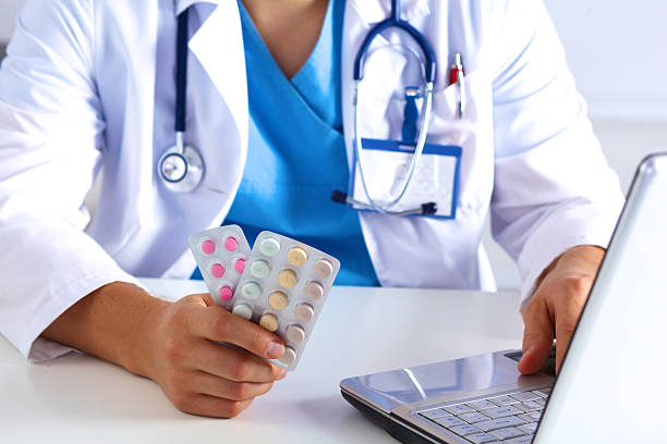 istock the doctor writes a prescription pill on the computer 623423852
