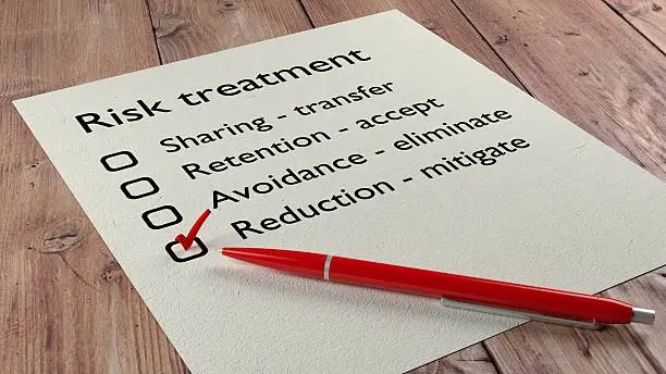 Risk treatment checklist where the word reduction mitigate has a red tickmark on a white paper list and a ball pen 3D illustration