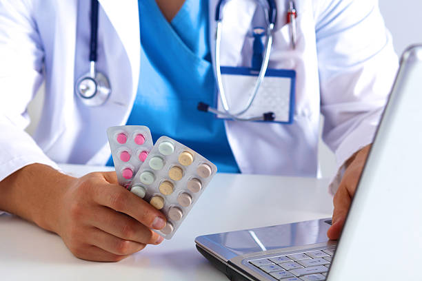 istock the doctor writes a prescription pill on the computer 623424004