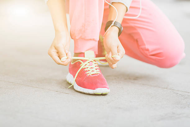 istock young chinese woman tying shoelace before run 623424408