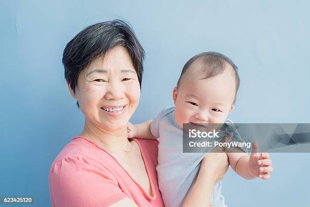 Grandmother Hug Her Grandson Happily Stock Photo - Download Image Now - Blue Background, Child, Grandparent