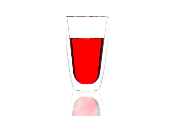 istock Red water in glass with reflection on white background 623425686