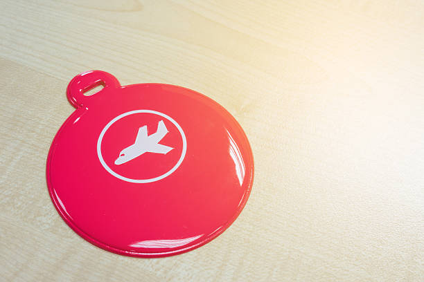 Circle pink luggage tag on wooden table