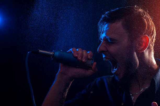 istock Young attractive male singer with microphone 623429676