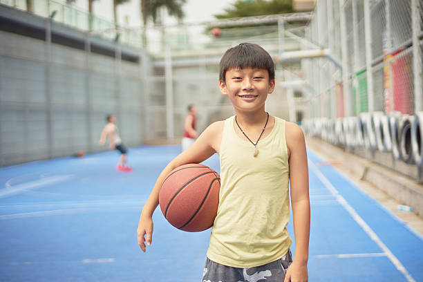 istock boy standing smiling at camera with basketball 623432218