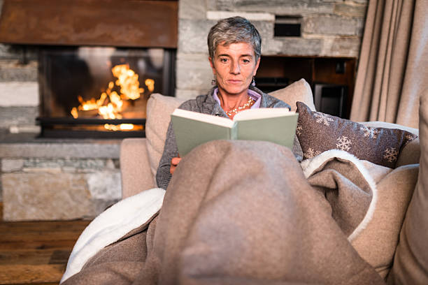 istock woman reading a book on the couch 623434020