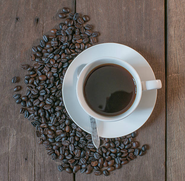 istock Coffee cup and coffee beans on old wooden desk 623435808