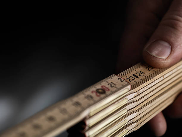 istock wooden folding ruler with a workings man hand 623435992