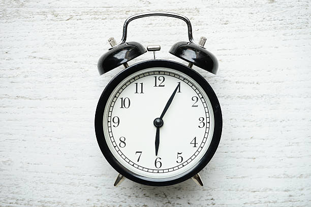 istock Retro alarm clock on wooden table 623437954