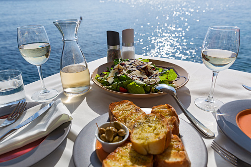 Table with food and wine on the background of the sea