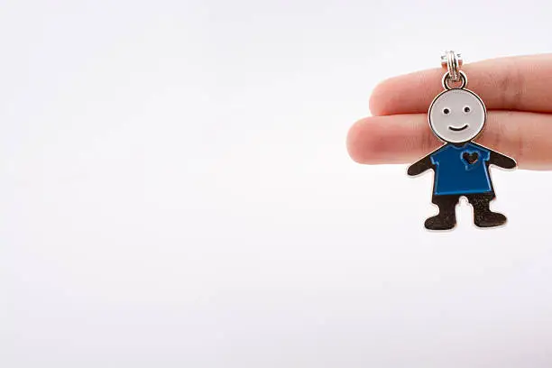 Man shaped keyholder in hand on white background