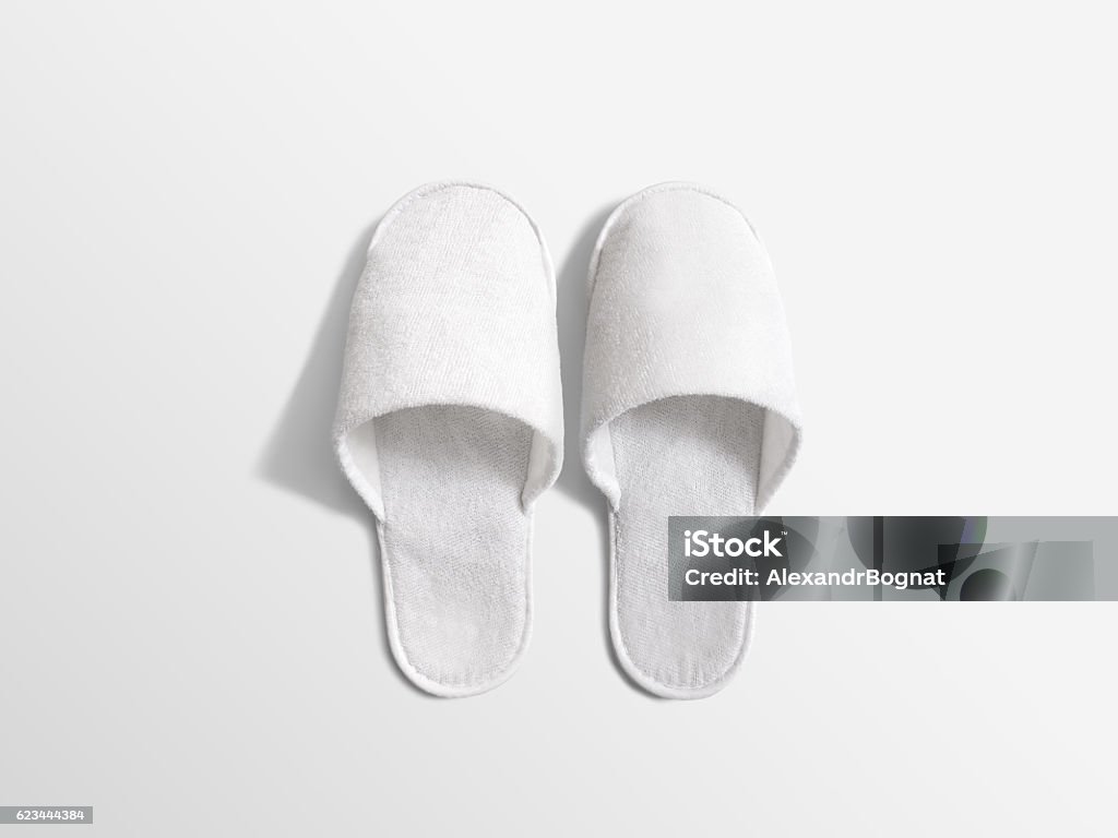 Pair of blank soft white home slippers, design mockup Pair of blank soft white home slippers, design mockup. House plain flops mock up template top view. Clear warm domestic sandal. Bed shoes accessory footwear. Slipper Stock Photo