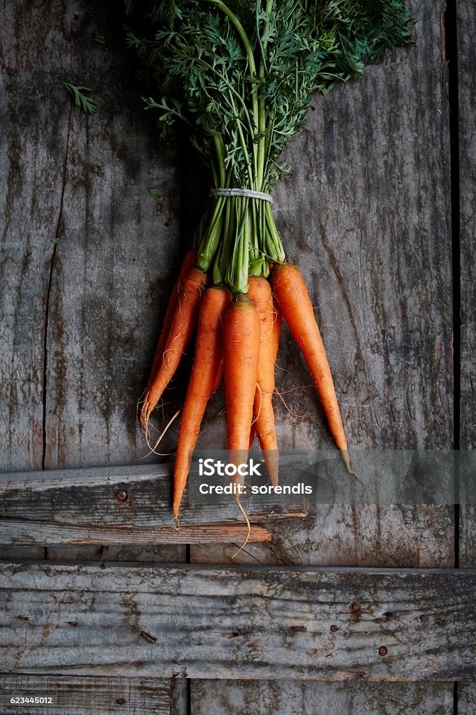 Bunch of Carrots Overhead view of bunch of carrots on wooden surface Carrot Stock Photo