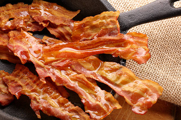 istock Hot fried bacon pieces in a cast iron skillet 623446820