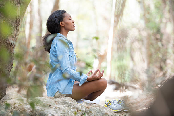 женщины, медитировать на открытом воздухе. - zen like nature breathing exercise sitting стоковые фото и изображения