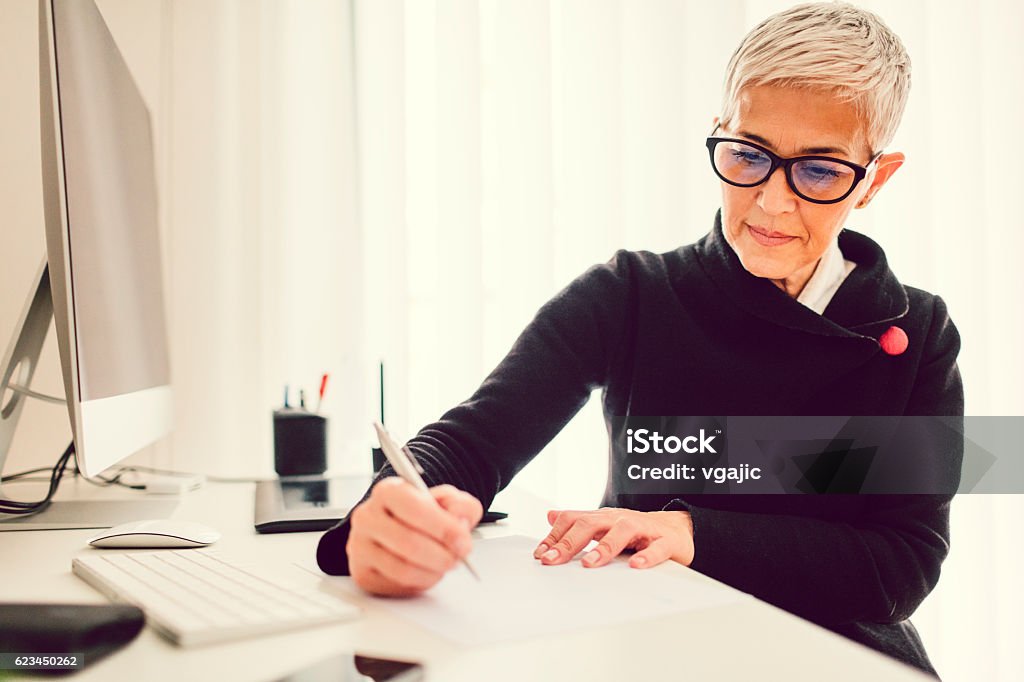 Reife Geschäftsfrau arbeitet in ihrem Home Office. - Lizenzfrei Schreiben Stock-Foto