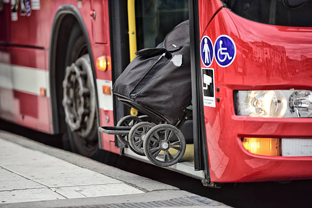 istock Person enters bus, pulling bag. City reflecting 623450284