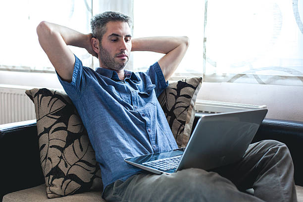 istock Man using laptop in the living room 623452688