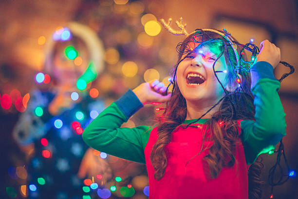 Children in Xmas Little girl and boy in Christmas playing with lights decorating stock pictures, royalty-free photos & images