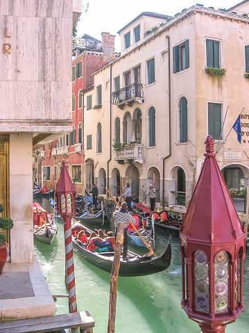 Venice, Italy - September 14, 2007: Traditional gondola boat on narrow canals of Venice taking tourists on tour. Italian city of Unesco Heritage.