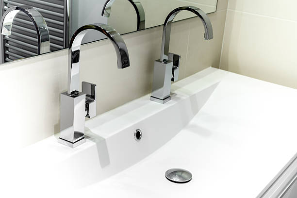 istock Modern Bathroom With Faucets On White Cabinet 623455218