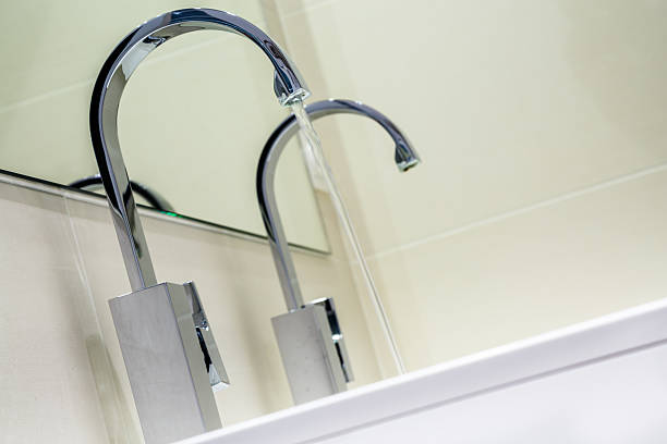 istock stainless steel faucet knob with flowing water 623455514