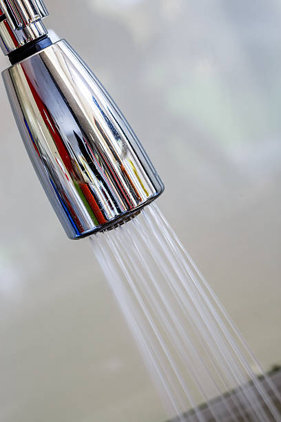 istock stainless steel faucet knob with flowing water 623455584