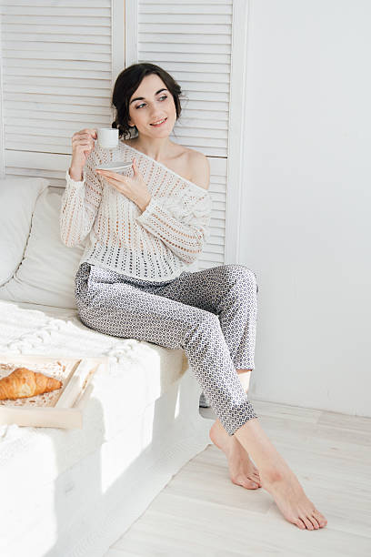 Girl drinking coffee and a croissant in bed