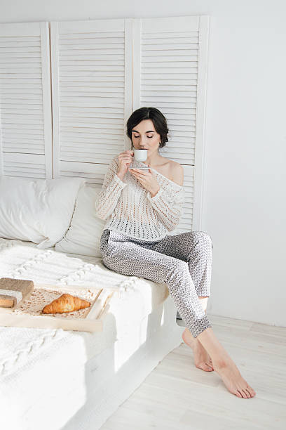 istock Girl drinking coffee and a croissant in bed 623458152