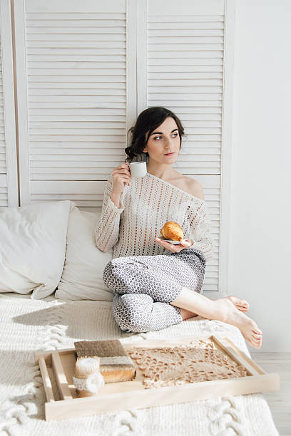 istock Girl drinking coffee and a croissant in bed 623473338