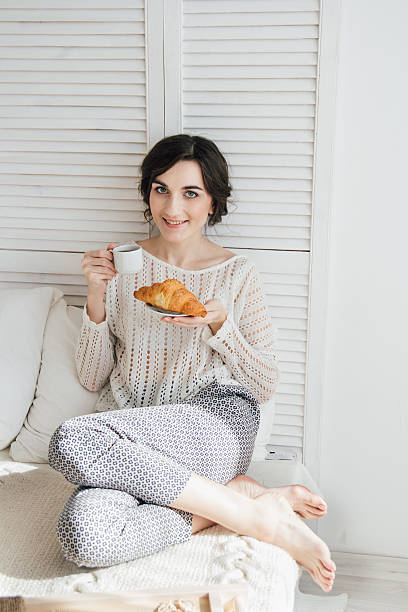 istock Girl drinking coffee and a croissant in bed 623474548