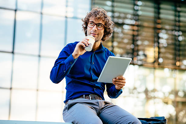 istock Cheerful businessman reading news on digital tablet 623475678