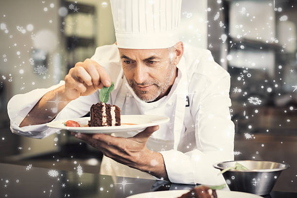 Snow falling against pastry chef decorating dessert in kitchen