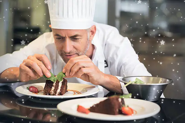 Photo of Snow against concentrated male pastry chef decorating dessert in kitchen