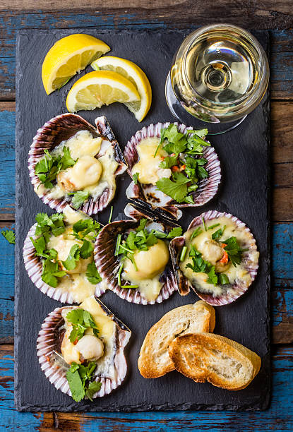 istock Baked scallops on slate with lemon, cilantro, bread white wine 623479994