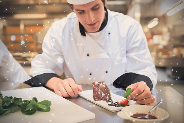 istock Snow against chef putting mint leaf with his dessert 623480468