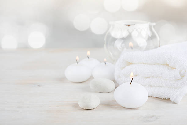 istock Spa resort therapy composition. Burning candles, stones, towel, abstract lights 623482628