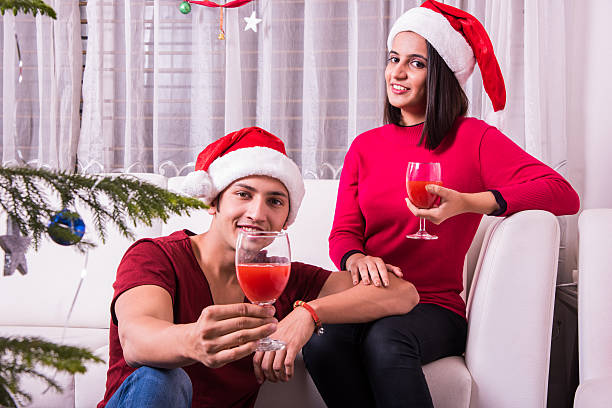 istock Young indian couple celebrating Christmas with drinks or wine 623482820