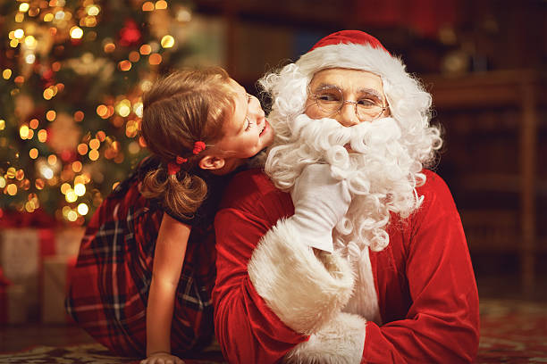istock happy child girl hugging Santa 623484990