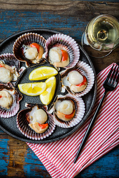 istock Raw scallops with lemon, cilantro on slate plate, white wine 623485126