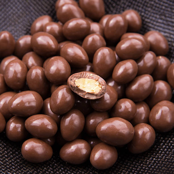 istock Chocolate ball candy smarties on black background with nuts inside 623485150
