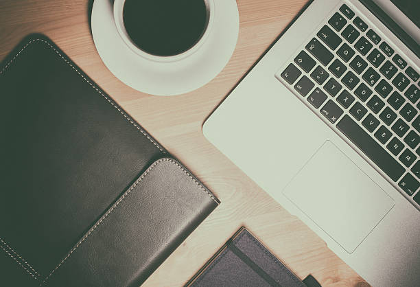 istock Notebook with bag on wooden table and a cup of 623485932