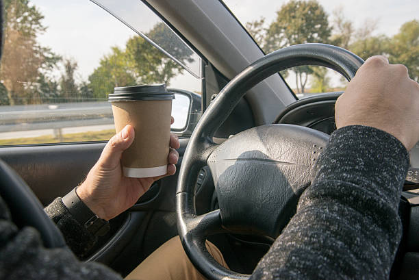 istock Mature  businessman drinking coffee and driving his car 623487124