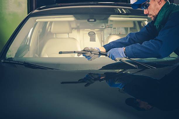 Windscreen Wiper Replacement Windscreen Wiper Replacement by Professional Auto Service Technician windshield wiper photos stock pictures, royalty-free photos & images