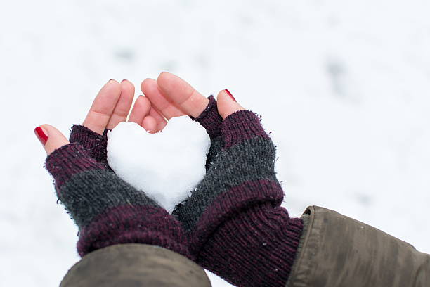 istock Woman hands holding heart shaped snowball 623497036