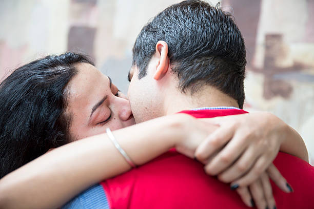 Young heterosexual couple kissing each other Young heterosexual couple in love, kissing each other. They are holding each other in an embrace and have locked their lips. indian couple kiss stock pictures, royalty-free photos & images