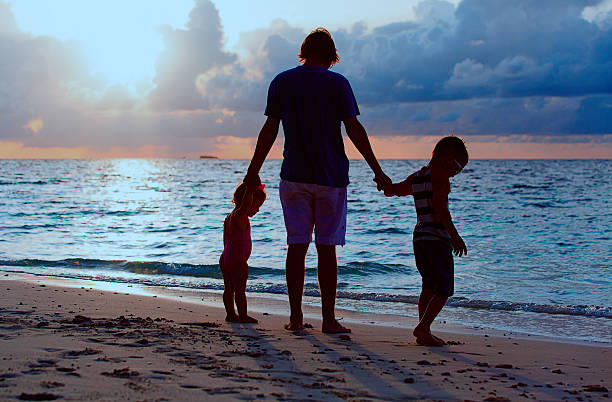 istock father and two kids walking at sunset 623499470