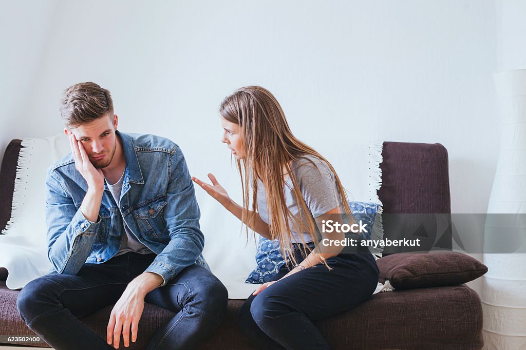 scandal, relationship problems in young family couple relationship problems in young family, angry woman wife and tired indifferent man husband Discussion Stock Photo